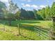 Picturesque property with green field, trees, and a metal gate at 2815 Orange Grove Rd, Hillsborough, NC 27278