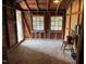Rustic shed with exposed beams, two windows, and a vintage chair, perfect for storage or a workshop at 2815 Orange Grove Rd, Hillsborough, NC 27278