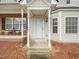 A close-up of the townhouse entryway, showcasing the covered porch and the front door with sidelight at 2845 Bennington Dr, Clayton, NC 27520