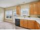 Efficient kitchen with laminate floors, white countertops, wooden cabinets, and black appliances at 2845 Bennington Dr, Clayton, NC 27520