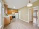 Traditional eat-in kitchen with wood cabinets, laminate flooring, and white appliances at 2845 Bennington Dr, Clayton, NC 27520
