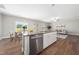 Open-concept kitchen with granite island, stainless steel dishwasher, and adjacent dining area at 304 Azalea Gaze Dr, Youngsville, NC 27596