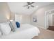 Bright main bedroom featuring a ceiling fan, ensuite bathroom, and neutral decor at 304 Azalea Gaze Dr, Youngsville, NC 27596