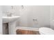 Simple powder room featuring pedestal sink, light gray walls, and wood-look floors at 304 Azalea Gaze Dr, Youngsville, NC 27596