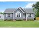 Charming single-story home with a well-maintained lawn, stylish gray siding, and white trim at 308 E Quailwood Dr, Fuquay Varina, NC 27526