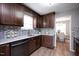 Well-equipped kitchen featuring dark wood cabinetry, mosaic backsplash, and granite countertops at 308 E Quailwood Dr, Fuquay Varina, NC 27526
