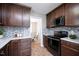Updated kitchen featuring dark wood cabinets, granite counters, and stainless steel appliances at 308 E Quailwood Dr, Fuquay Varina, NC 27526