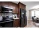 Contemporary kitchen with stainless steel appliances, dark wood cabinets, and a mosaic tile backsplash at 308 E Quailwood Dr, Fuquay Varina, NC 27526