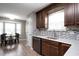 Modern kitchen with dark wood cabinets, stainless steel appliances, and an adjacent dining area at 308 E Quailwood Dr, Fuquay Varina, NC 27526