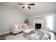 Bright living room featuring a fireplace, ceiling fan, and a comfortable sofa with stylish pillows at 308 E Quailwood Dr, Fuquay Varina, NC 27526