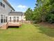 Backyard with green grass, a wooden deck and partial views of the neighboring houses at 324 Farrow Glen Loop, Cary, NC 27519