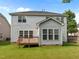 Well-maintained backyard with lush green grass and a home featuring a sunroom and deck at 324 Farrow Glen Loop, Cary, NC 27519