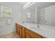 Bathroom with double vanity, large mirror, and decorative light fixture at 324 Farrow Glen Loop, Cary, NC 27519