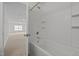 Bathroom with white tiled shower and bathtub; an open door leads into another room at 324 Farrow Glen Loop, Cary, NC 27519