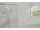 Modern bathroom with glass shower and luxurious soaking tub near a window at 324 Farrow Glen Loop, Cary, NC 27519