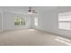 Spacious bedroom with plush carpeting, ceiling fan, and multiple windows for natural light at 324 Farrow Glen Loop, Cary, NC 27519