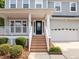 Inviting front porch and entrance with wooden steps, white railings, and a classic blue front door at 324 Farrow Glen Loop, Cary, NC 27519