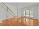 Open-concept living space with gleaming hardwood floors, staircase, and plenty of natural light at 324 Farrow Glen Loop, Cary, NC 27519