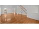 Expansive living area with hardwood floors, leading to kitchen, with staircase and multiple windows at 324 Farrow Glen Loop, Cary, NC 27519