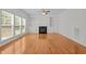 Sunlit living room featuring hardwood floors, built-in shelving, and a cozy fireplace at 324 Farrow Glen Loop, Cary, NC 27519