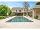 Beautiful backyard view with a pool, guest house, lush green lawn, and manicured landscaping at 3347 Alamance Dr, Raleigh, NC 27609