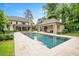 Gorgeous backyard showcasing pool, guest house, covered patio, and lush landscaping at 3347 Alamance Dr, Raleigh, NC 27609