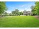 Sprawling backyard with a lush green lawn and mature trees provides ample space for recreation at 3347 Alamance Dr, Raleigh, NC 27609