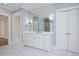 Spacious bathroom features a white vanity, marble countertops, and a large mirror for a luxurious feel at 3347 Alamance Dr, Raleigh, NC 27609