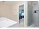 Bathroom featuring a shower with glass door, neutral walls and a view into the bedroom area at 3347 Alamance Dr, Raleigh, NC 27609