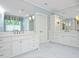 Bright bathroom with dual vanities, marble countertops, and large mirrors offering a spa-like experience at 3347 Alamance Dr, Raleigh, NC 27609