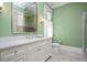 Elegant bathroom features a white vanity, a large mirror, and a separate glass-enclosed shower with green walls at 3347 Alamance Dr, Raleigh, NC 27609