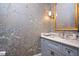 Charming powder room with floral wallpaper, a gold-framed mirror, and blue vanity with a marble countertop at 3347 Alamance Dr, Raleigh, NC 27609