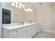 Bright bathroom features a double sink vanity with white countertop and cabinets, and a large mirror at 3347 Alamance Dr, Raleigh, NC 27609