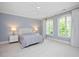 Serene bedroom with large windows, neutral walls, and plush carpeting at 3347 Alamance Dr, Raleigh, NC 27609
