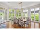 Dining room filled with natural light from large windows and a modern chandelier at 3347 Alamance Dr, Raleigh, NC 27609