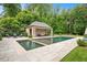 A stone patio with an outdoor seating area and fire pit provides an inviting space to relax with a pool house at 3347 Alamance Dr, Raleigh, NC 27609