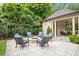 A stone fire pit is surrounded by comfortable seating for relaxation in this landscaped backyard, with an outdoor shelter at 3347 Alamance Dr, Raleigh, NC 27609