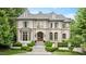 Elegant stone-clad home with manicured landscaping, arched windows, and a welcoming front entrance at 3347 Alamance Dr, Raleigh, NC 27609