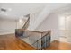 Bright hallway with dark wood floors, black metal railings and a staircase leading to the upper level at 3347 Alamance Dr, Raleigh, NC 27609