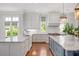 Bright kitchen featuring marble countertops, two islands, and white cabinetry at 3347 Alamance Dr, Raleigh, NC 27609