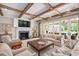 Bright living room featuring beamed ceilings, fireplace, and patio access at 3347 Alamance Dr, Raleigh, NC 27609