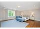 Spacious main bedroom with hardwood floors, large windows, and a cozy chaise lounge and bed at 3347 Alamance Dr, Raleigh, NC 27609