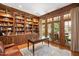 Wood-paneled office with built-in bookshelves and French doors leading to outdoor patio at 3347 Alamance Dr, Raleigh, NC 27609