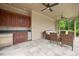 Charming pool house featuring a kitchenette, comfortable seating, and ceiling fans for outdoor relaxation at 3347 Alamance Dr, Raleigh, NC 27609