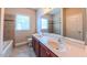 Bathroom featuring double vanity, a large mirror, and a bathtub and shower combo at 3408 Mount Pisgah Way, Cary, NC 27519