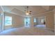 Large bedroom with tray ceiling, ceiling fan, large windows, and ensuite bathroom access at 3408 Mount Pisgah Way, Cary, NC 27519