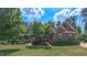 Charming brick home with lush landscaping, mature trees and a well-manicured lawn at 3408 Mount Pisgah Way, Cary, NC 27519