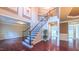 Grand foyer showcasing beautiful hardwood floors, a staircase with rod iron spindles and tasteful wall decor at 3408 Mount Pisgah Way, Cary, NC 27519