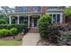 Inviting front porch with stately columns and manicured hedges, creating a welcoming entrance to this brick home at 3408 Mount Pisgah Way, Cary, NC 27519