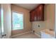 Functional laundry room features a utility sink, cabinet, and window for natural light at 3408 Mount Pisgah Way, Cary, NC 27519
